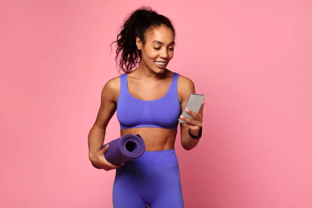 Gym member taking a photo beside a neon sign